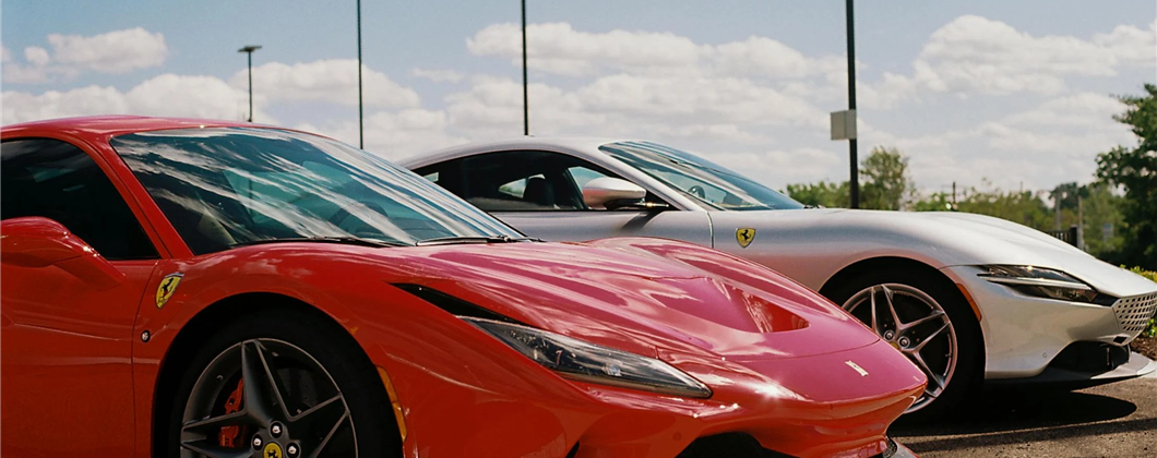 Two Ferrari supercars lined up on a road.